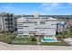 Exterior shot of a condominium building with a pool, shuffleboard and well manicured lawns by the beach at 7000 Beach Plz # 505, St Pete Beach, FL 33706