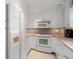 Clean galley kitchen featuring white appliances and cabinets at 7000 Beach Plz # 505, St Pete Beach, FL 33706