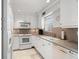 Bright kitchen featuring white cabinetry, stainless steel appliances, and a window for natural light at 7000 Beach Plz # 505, St Pete Beach, FL 33706