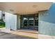 Building entrance with glass doors and landscaping at 300 Woodette Dr # 202B, Dunedin, FL 34698