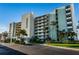 Multi-story building with palm trees and landscaping at 300 Woodette Dr # 202B, Dunedin, FL 34698