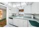 White kitchen with view to living room at 300 Woodette Dr # 202B, Dunedin, FL 34698
