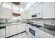 White kitchen with appliances and green countertops at 300 Woodette Dr # 202B, Dunedin, FL 34698
