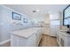 Modern kitchen with white cabinets and marble island at 300 Woodette Dr # 202B, Dunedin, FL 34698