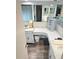 Bright bathroom features double sinks, a vanity area, and wood-look floors, creating a stylish and functional space at 1172 Chelsea Ln, Holiday, FL 34691