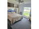 Comfortable bedroom features a bright window, ceiling fan, and built-in shelves, creating a relaxing and functional space at 1172 Chelsea Ln, Holiday, FL 34691