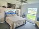 Cozy bedroom with a ceiling fan and bright window offering natural light and views of the yard and neighborhood at 1172 Chelsea Ln, Holiday, FL 34691
