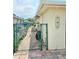 Side view of the house with a gated entrance, showing a walkway to the backyard at 1172 Chelsea Ln, Holiday, FL 34691