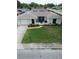 Charming single-story home boasts a well-manicured lawn and a welcoming front patio with stylish decor at 1172 Chelsea Ln, Holiday, FL 34691