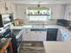 Bright kitchen featuring white cabinets, modern appliances, and a window with decorative plants at 1172 Chelsea Ln, Holiday, FL 34691