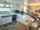 Open kitchen area with an eat-in bar, white countertops, and a view into the adjacent dining area at 1172 Chelsea Ln, Holiday, FL 34691