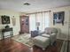 Bright and airy living room featuring a decorative cabinet, accent chair and ottoman, and a large window for natural light at 1172 Chelsea Ln, Holiday, FL 34691