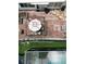 This aerial view shows a brick patio, an umbrella with seating, and an enclosed pool area, perfect for outdoor relaxation at 1172 Chelsea Ln, Holiday, FL 34691