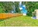 Large backyard with a wooden fence and mature trees at 10162 115Th Ave, Largo, FL 33773