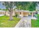 Cute yellow house with carport and mature landscaping at 10162 115Th Ave, Largo, FL 33773