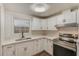 Modern kitchen with white cabinets, quartz countertops and stainless steel appliances at 10162 115Th Ave, Largo, FL 33773