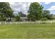 House exterior featuring a white fence and lush green lawn at 3130 Long Rifle Dr, Wimauma, FL 33598