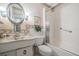 This bathroom features a unique oval mirror, marble sink, toilet and enclosed shower at 2700 Bayshore Blvd # 559, Dunedin, FL 34698