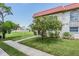 Exterior view of the property featuring well-maintained lawn, sidewalk, and attractive landscaping at 2700 Bayshore Blvd # 559, Dunedin, FL 34698