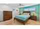 Guest bedroom with teal accent wall and wood furniture at 5000 Gulf Blvd # 704, St Pete Beach, FL 33706