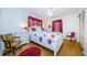 Bright bedroom with a white wooden bed frame and red floral bedding at 7787 39Th N Ter # 7787, St Petersburg, FL 33709