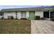 Front view of a single story home with green door and landscaping at 7787 39Th N Ter # 7787, St Petersburg, FL 33709