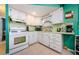 L-shaped kitchen with white cabinets and teal walls at 7787 39Th N Ter # 7787, St Petersburg, FL 33709