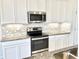 Close-up of kitchen with granite countertops and stainless steel appliances at 10188 Cross Timber Ter, Land O Lakes, FL 34638