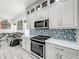 Modern kitchen with white cabinets, stainless steel appliances, and marble countertops at 2325 Pleasant Hill Ln, Holiday, FL 34691