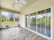 Relaxing screened porch with wood-look tile floor and ceiling fan at 2325 Pleasant Hill Ln, Holiday, FL 34691