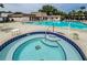 Community pool and spa with ample lounge chairs at 2400 Winding Creek Blvd # 25-101, Clearwater, FL 33761