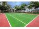 Green tennis court with red perimeter at 2400 Winding Creek Blvd # 25-101, Clearwater, FL 33761