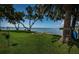 Beautiful backyard with lush lawn, trees, and serene waterfront views at 4751 Baywood Point S Dr, Gulfport, FL 33711