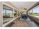 Enclosed porch featuring ceiling fans, tiled floors, and expansive views of the pool and bay at 4751 Baywood Point S Dr, Gulfport, FL 33711