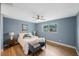 Serene bedroom with light blue walls, hardwood floors, and a ceiling fan at 1995 Arvis E Cir, Clearwater, FL 33764