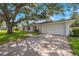 Newly renovated home with a large oak tree and driveway at 1995 Arvis E Cir, Clearwater, FL 33764