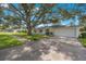 Newly renovated home with a large oak tree and sidewalk at 1995 Arvis E Cir, Clearwater, FL 33764