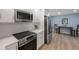 Modern kitchen with white shaker cabinets, quartz countertops, and stainless steel appliances at 1995 Arvis E Cir, Clearwater, FL 33764