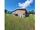 Rear view of mobile home with AC unit and yard at 283 Pelican N Dr, Oldsmar, FL 34677