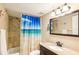 Bathroom with tile-lined shower, a vanity and an ocean themed shower curtain at 2085 Hunters Glen Dr # 213, Dunedin, FL 34698