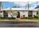 Condominium exterior with red arrow pointing toward unit entrance and well-maintained landscaping at 2085 Hunters Glen Dr # 213, Dunedin, FL 34698