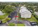 Exterior view of a condo building with an adjacent parking lot and verdant, mature landscaping at 2085 Hunters Glen Dr # 213, Dunedin, FL 34698