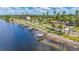 Waterfront view featuring docks, palm trees, and residential homes along a scenic road at 2085 Hunters Glen Dr # 213, Dunedin, FL 34698