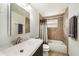 Well-lit bathroom featuring a vanity with a sink, a toilet, and a shower-tub combo with brown tile at 707 2Nd Se St, Largo, FL 33771