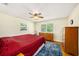 Cozy bedroom with a red bedspread, wood floors, and natural light from the window at 707 2Nd Se St, Largo, FL 33771