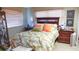 Bedroom with floral bedding, wooden furniture, and window blinds at 1847 Oak Lake Dr, Clearwater, FL 33764