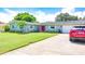 Ranch-style home with a red door, attached garage, and well-manicured lawn at 1847 Oak Lake Dr, Clearwater, FL 33764