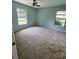 Large bedroom with light teal walls and plush carpeting, plus two windows at 8356 Candlewood Rd # 0, Seminole, FL 33777