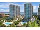 Stunning aerial view of luxury high-rise condos with pools, lush landscaping, and waterfront access at 1170 Gulf Blvd # 1005, Clearwater Beach, FL 33767