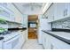 White kitchen with granite countertops and mosaic backsplash at 1893 Shore S Dr # 206, South Pasadena, FL 33707